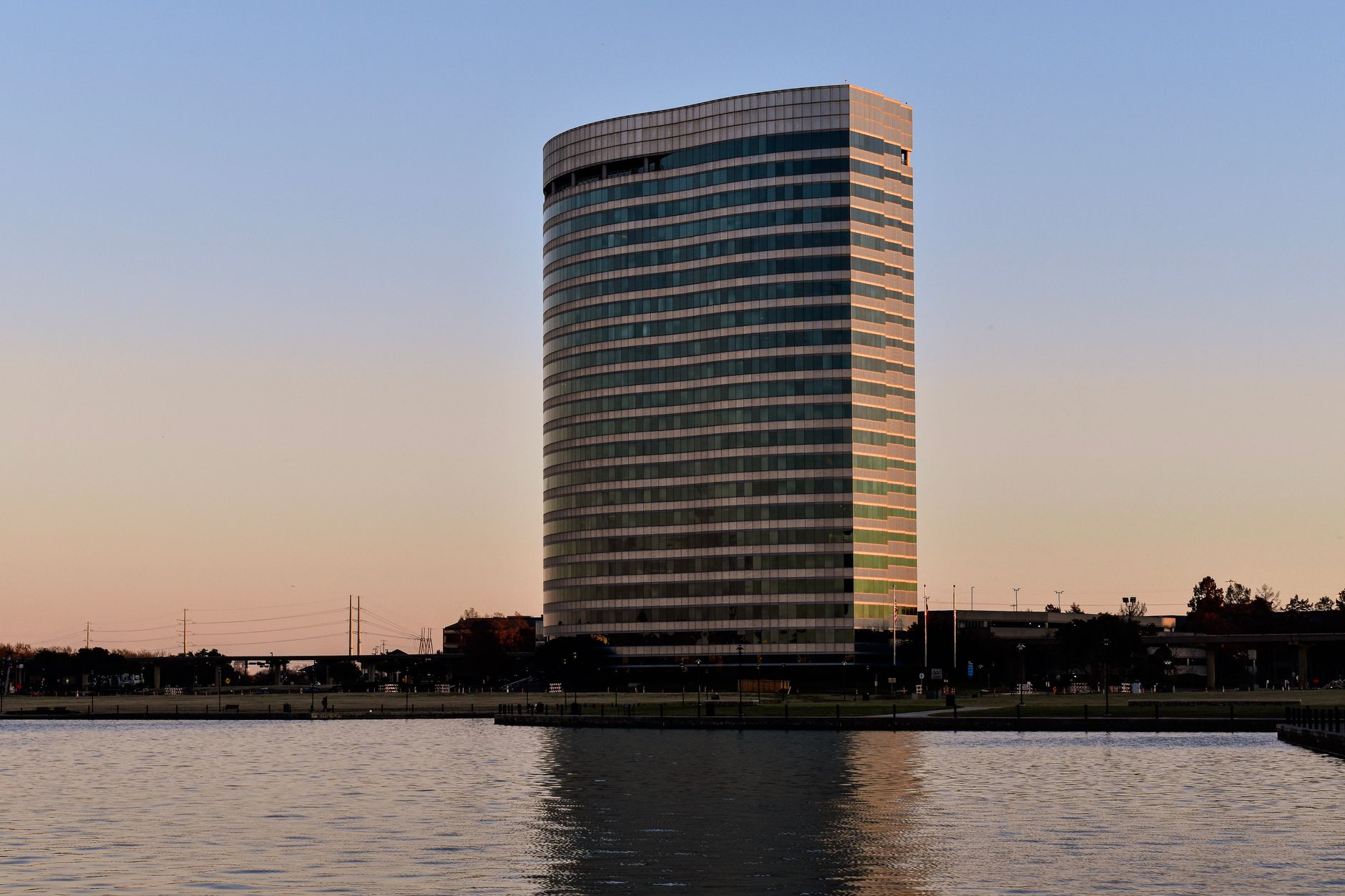 A sleek office building reflected on a lake at sunset in Irving, Texas, USA.