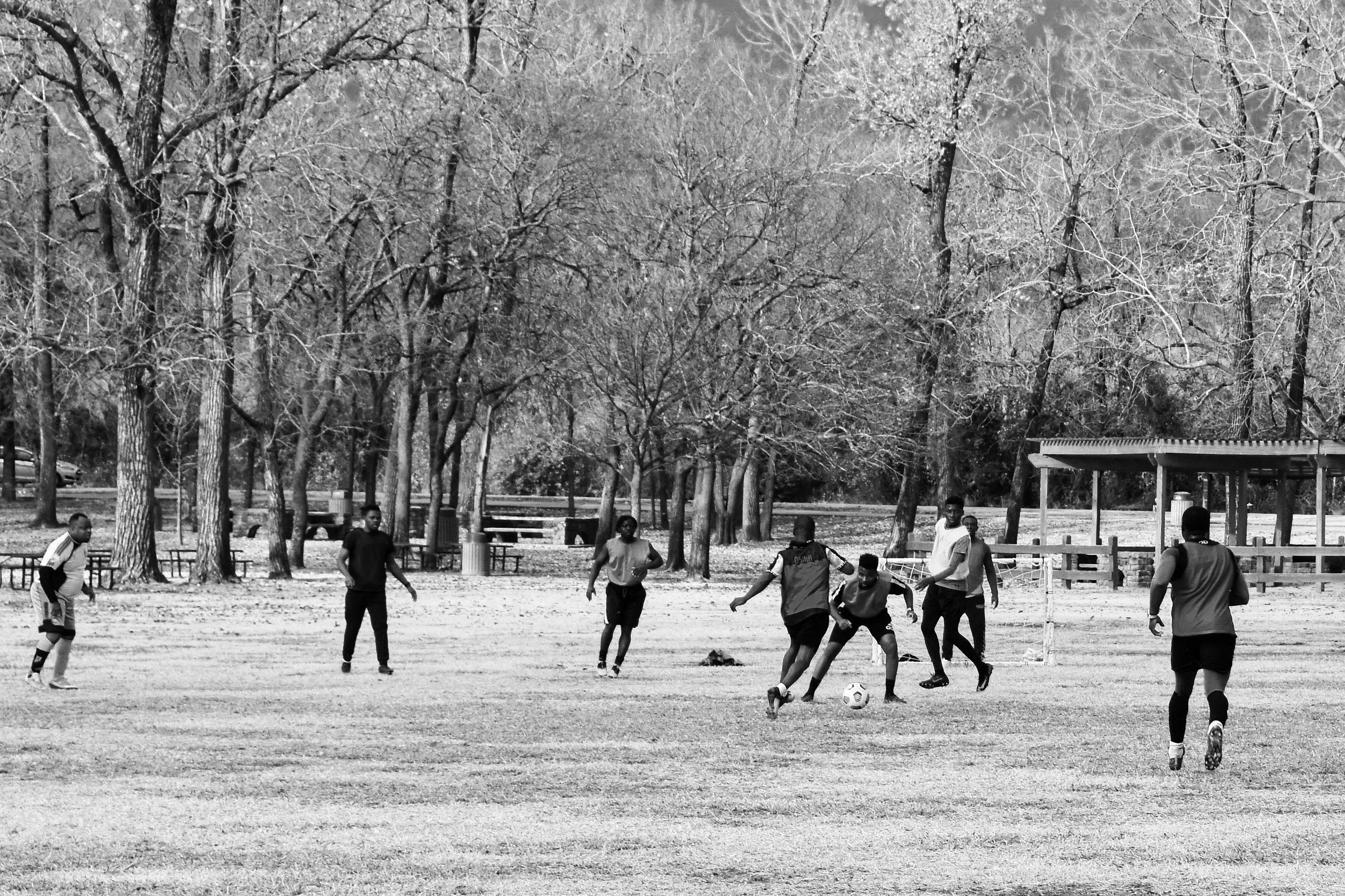 grayscale photo of people playing soccer