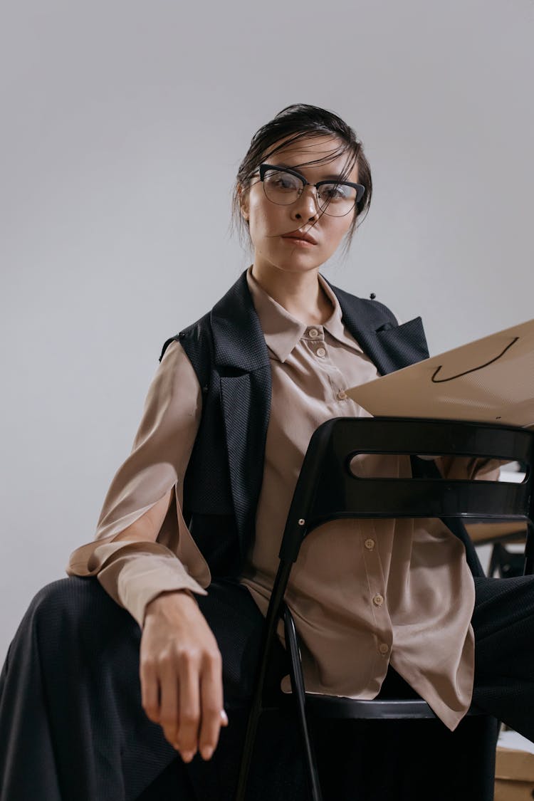 A Woman With Messy Hair Sitting Backwards On A Chair