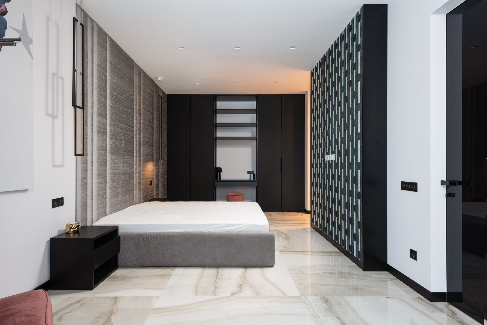 Interior of contemporary bedroom with mattress on bed near table and cabinet with decorative objects
