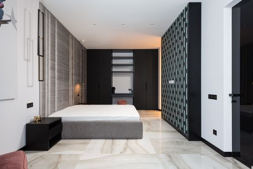Free Interior of contemporary bedroom with mattress on bed near table and cabinet with decorative objects Stock Photo