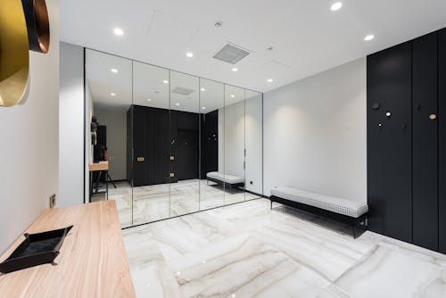 Interior of modern apartment with marble floor covering white walls and mirror wardrobe