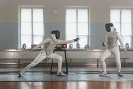 People in Fencing Uniforms Practicing Fencing in a Studio