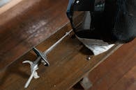 A Fencer Mask and Sword over a Wooden Bench