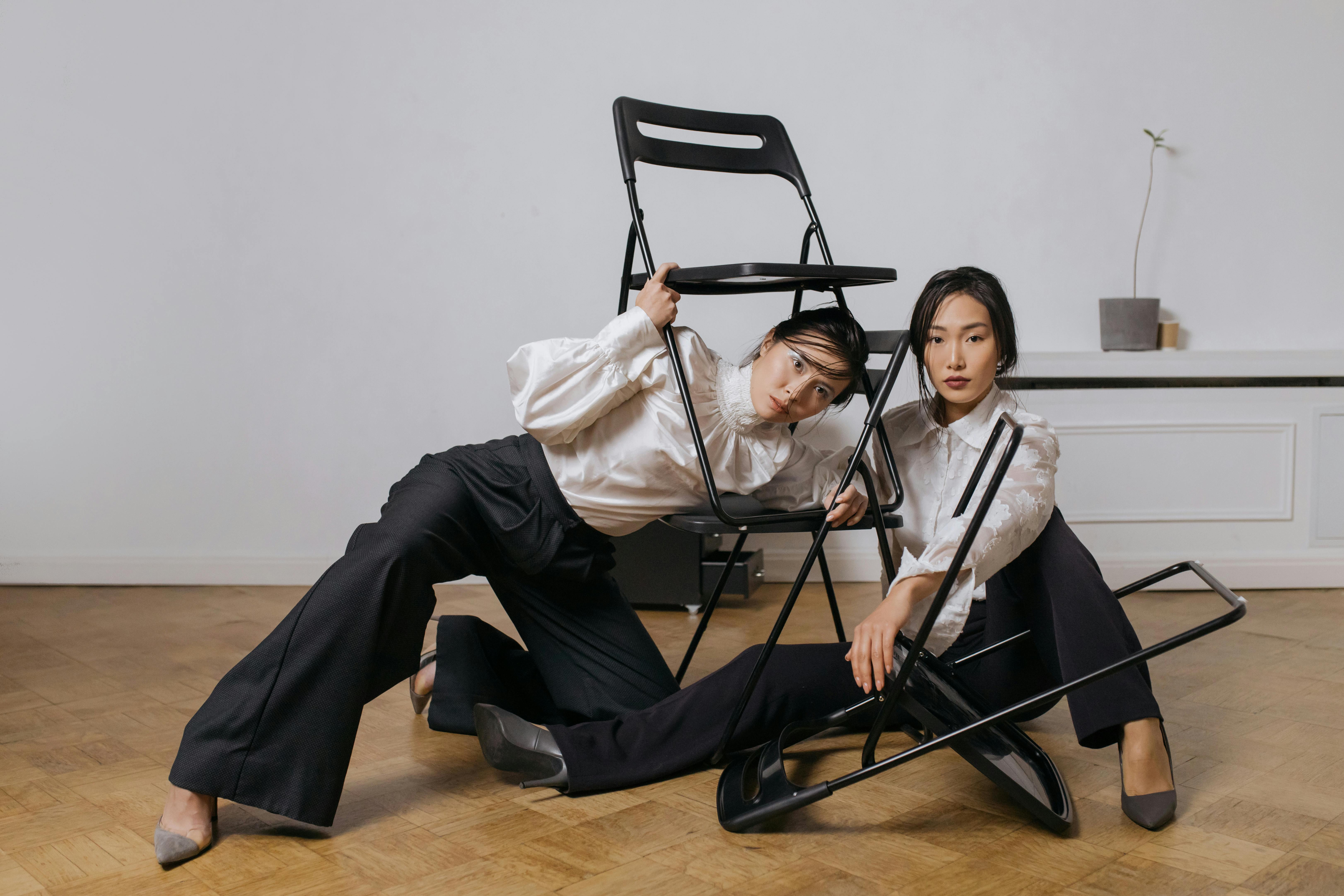 young women tangled in folding chairs