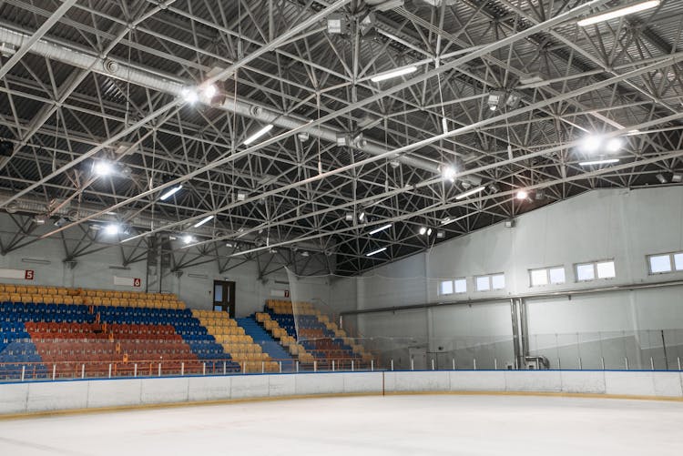 An Ice Rink With Lights Hanging On Steel Bars