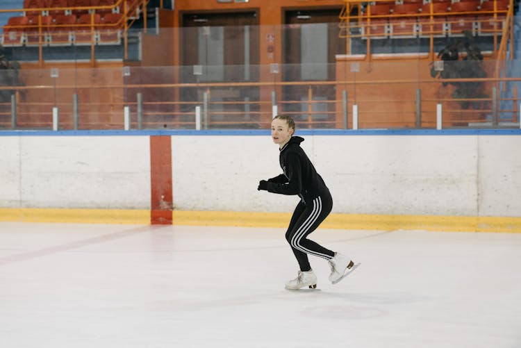 A Girl Gliding With Ice Skates On The Ice Rink