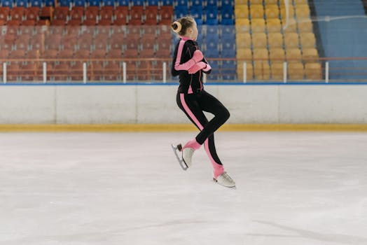 A young figure skater in motion, showcasing skill and grace on an indoor ice rink.