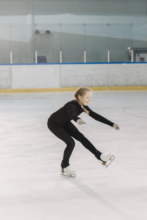 Girl in Black Long Sleeve Shirt and Pants Wearing White Ice Skating Shoes