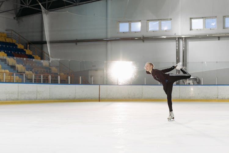 A Young Woman Ice Skating On The Ice Rink