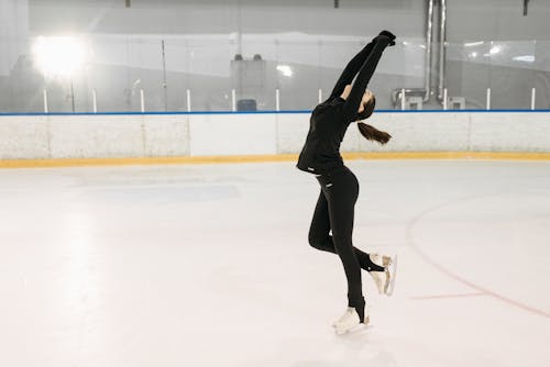 A Woman Figure Skating on the Ice Rink