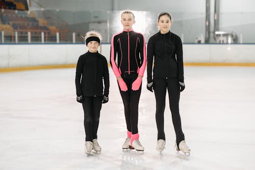 Free Girls with Ice Skates Standing on the Ice Rink Stock Photo