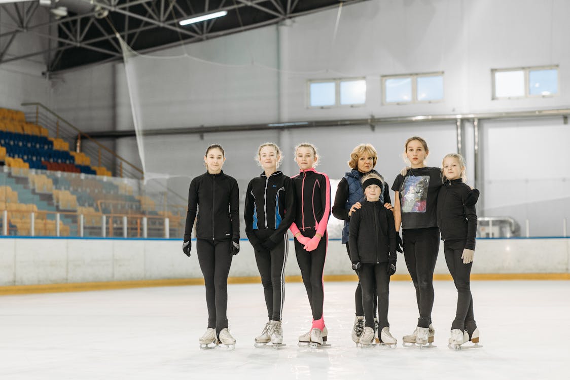 Free Group of Girls Standing on Indoor Ice Rink Stock Photo