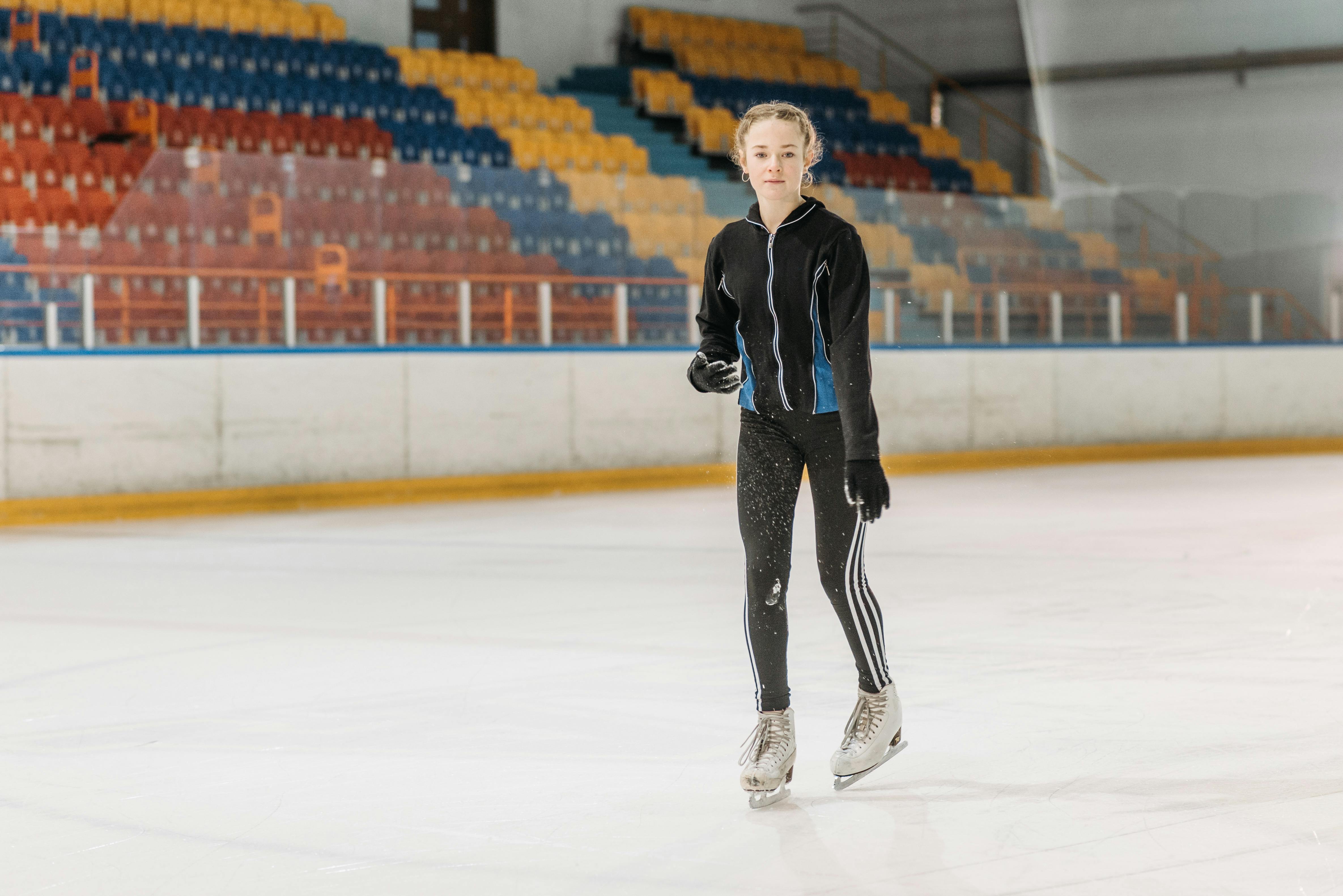 a young woman gliding on the ice rink with ice skates