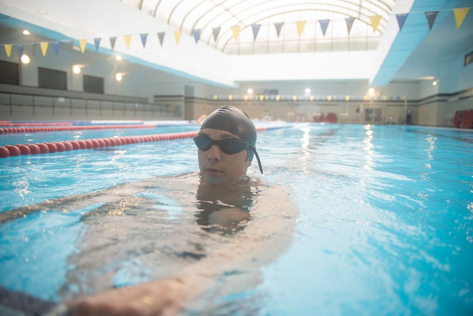 An adult swimmer practicing consistent lap swimming in a clean indoor facility An adult swimmer practicing consistent lap swimming in a clean indoor facility