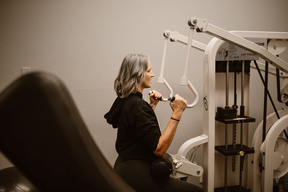 Coach reviewing a training plan with a client sitting on a gym ball