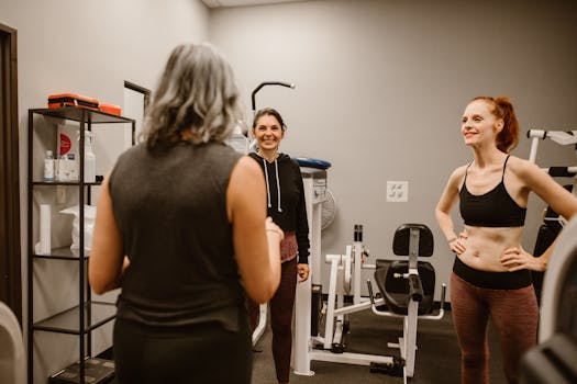 Three women engaging in a fitness session in a well-equipped gym.