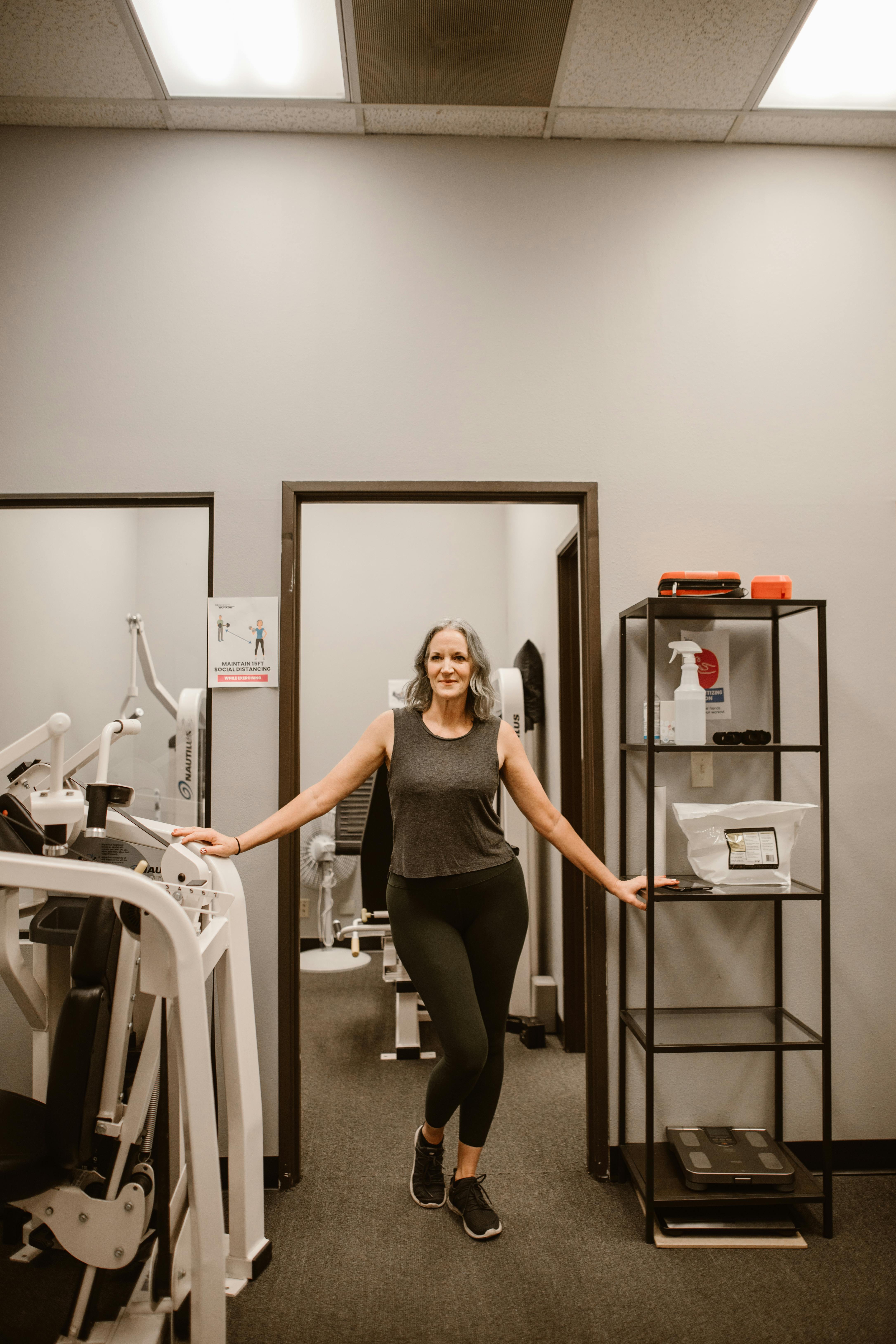 Confident senior woman in fitness studio embracing wellness and empowerment.
