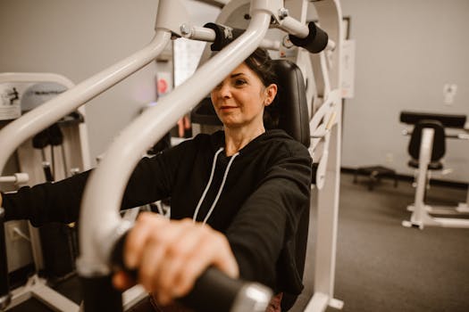 Woman working out on gym equipment focusing on fitness and a healthy lifestyle.