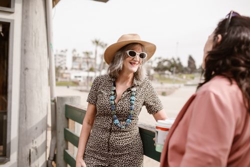 Free Two stylish women chatting outdoors, showcasing summer fashion and joy. Stock Photo