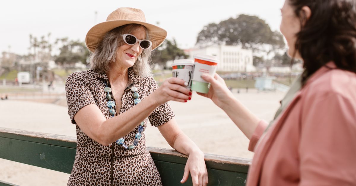 Two women enjoying a day outdoors, toasting with coffee in a sunny setting. - Evidence evidence guide for maca hot flashes randomized trial