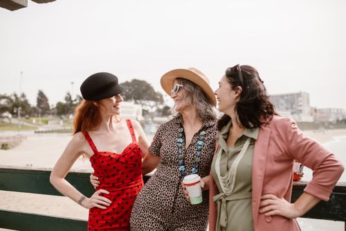 Free Three friends laughing and enjoying a sunny day at the beach. Stock Photo