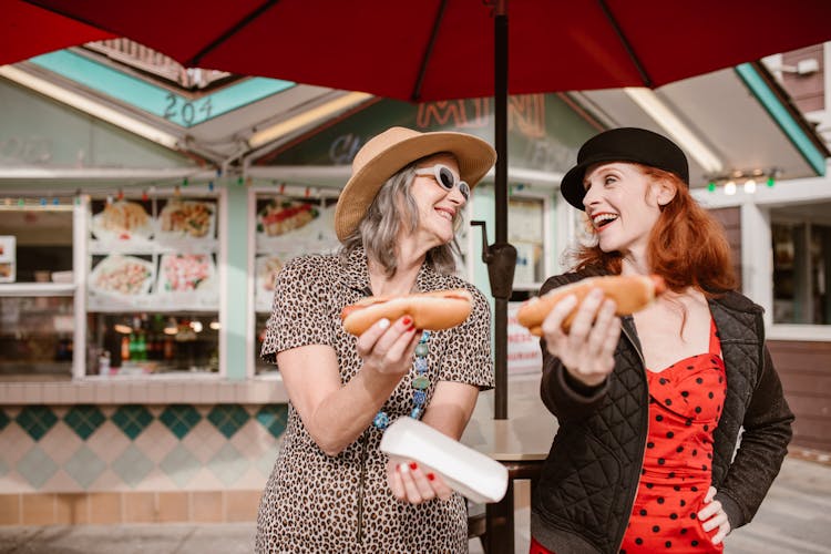 Two Women Holding Hotdogs