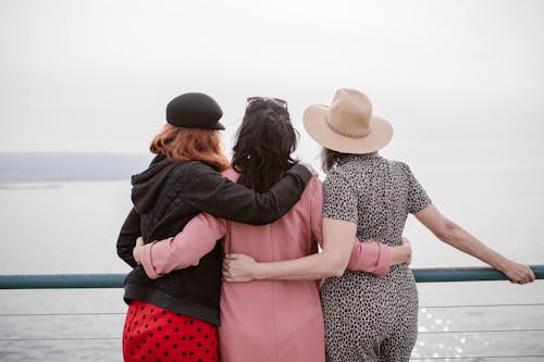 Free People Hugging while Looking at the Beach Stock Photo