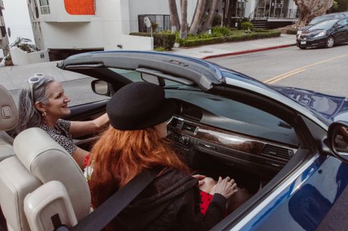 Free Two women enjoy a leisurely drive in a convertible at Redondo Beach, capturing the essence of freedom and adventure. Stock Photo