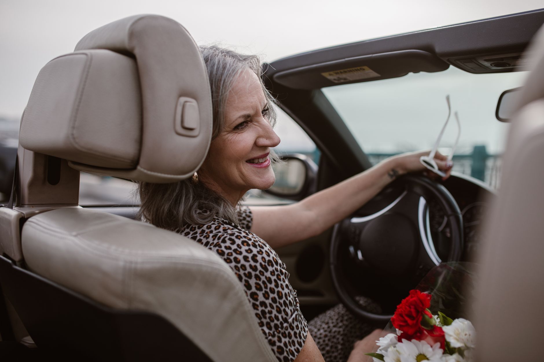 Elderly man gripping steering wheel looking confused and disoriented on a residential street