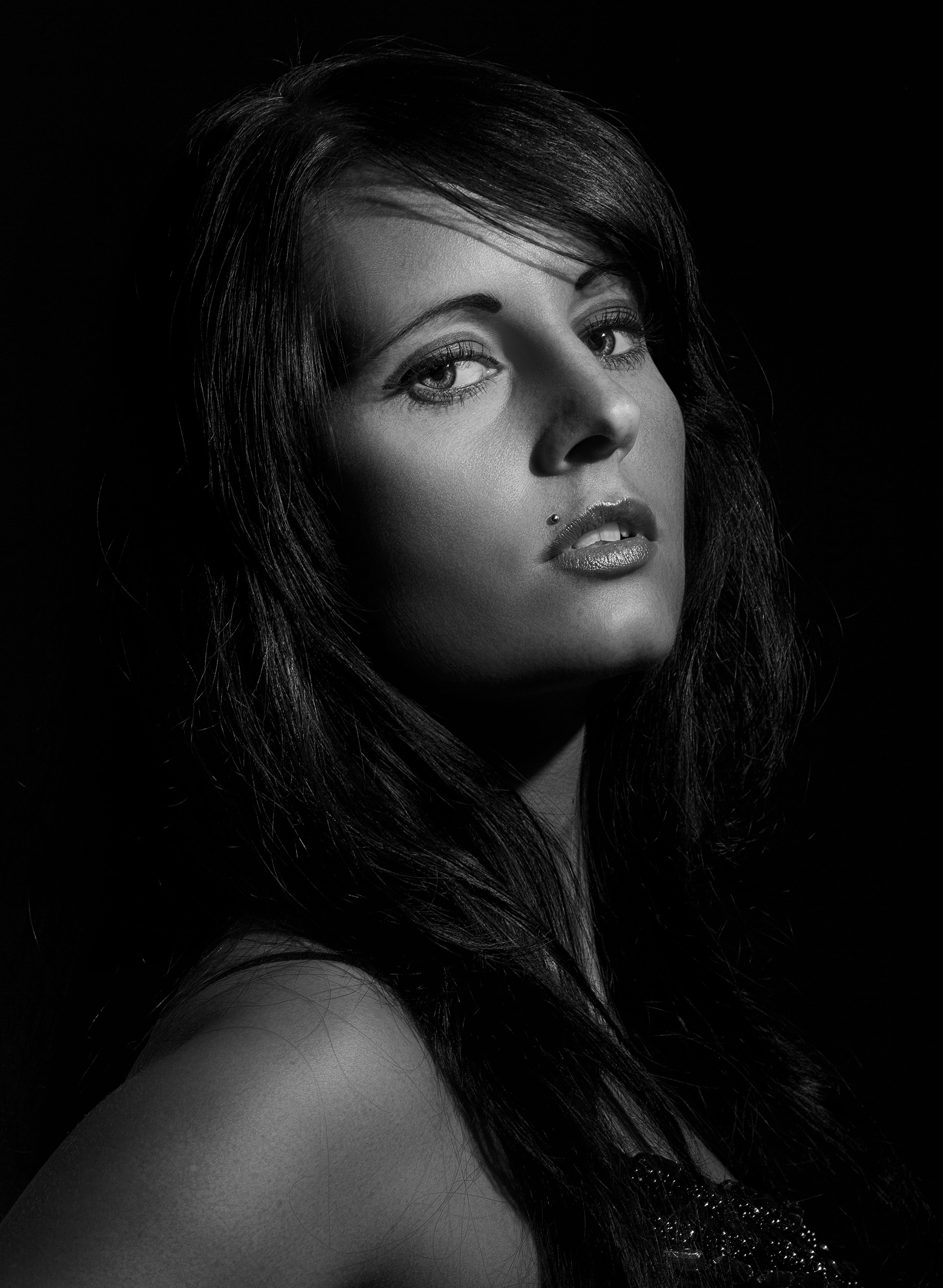 Striking black and white portrait capturing the emotion and beauty of a woman in low light.