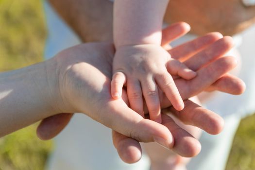 Close-up of parent and child's hands symbolizing love and connection.