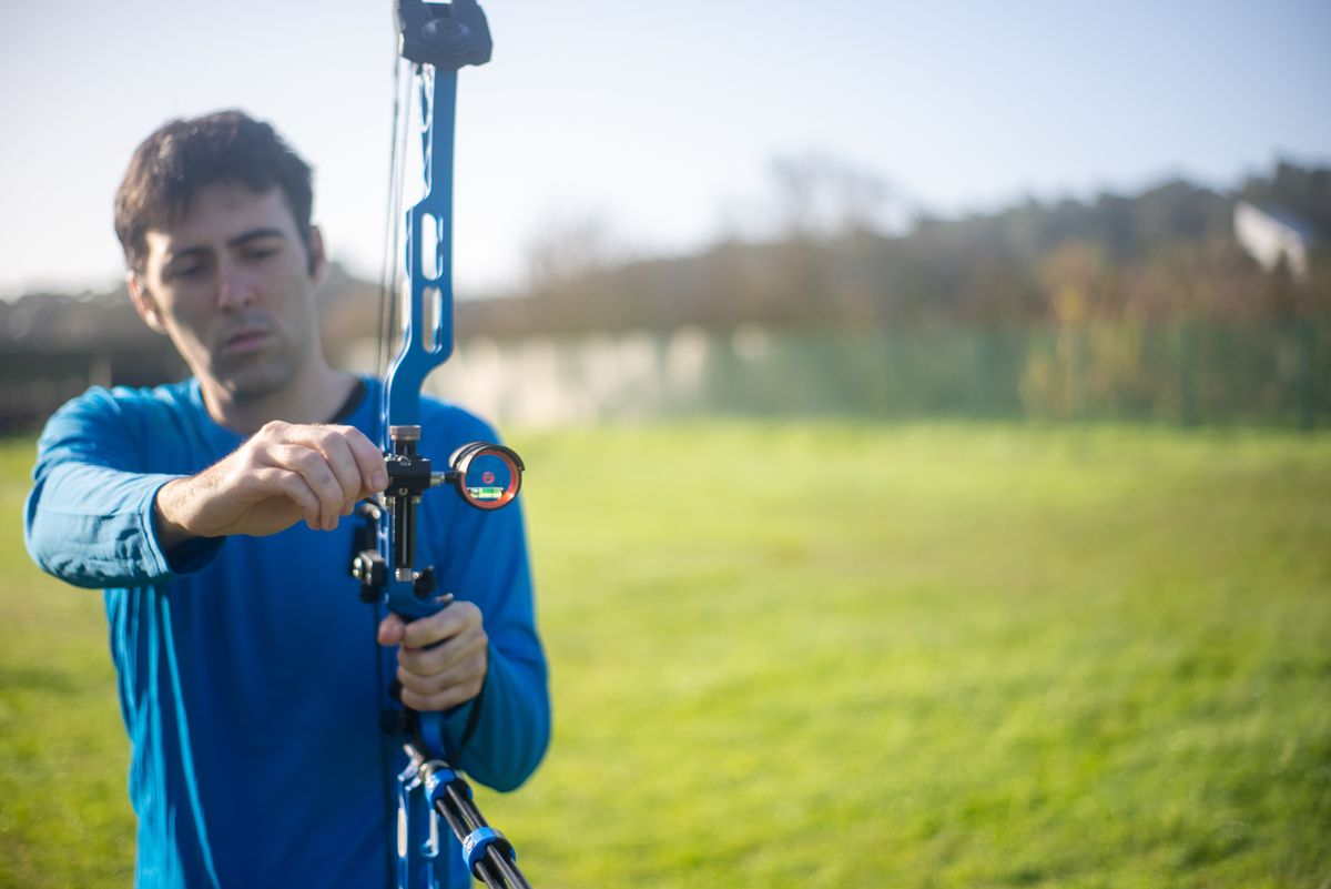 Archer aiming a bow outdoors