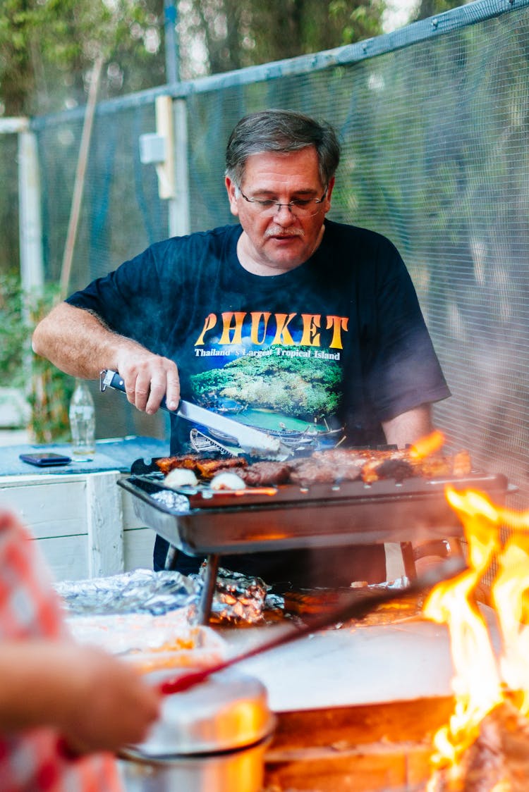 A Man Grilling Food Outdoors