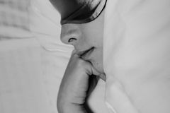 Black and white image of a woman sleeping peacefully with a sleep mask on.