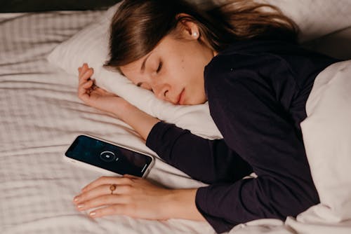 Free Pretty Woman Sleeping Beside Her Cellphone Stock Photo