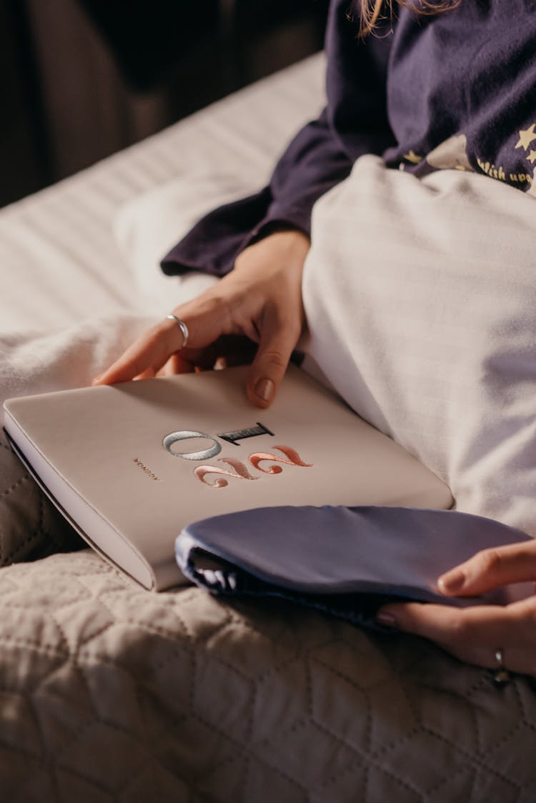 A Person Sitting On Bed Holding 2021 Diary