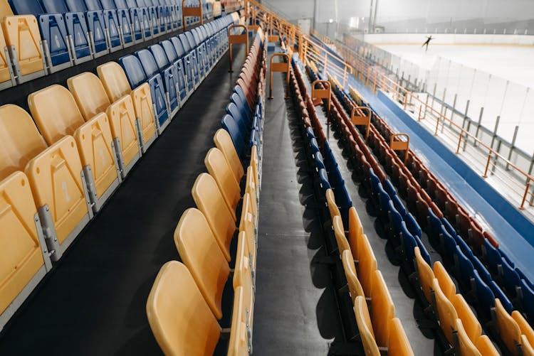 A Person Ice Skating On A Stadium With Empty Bleachers
