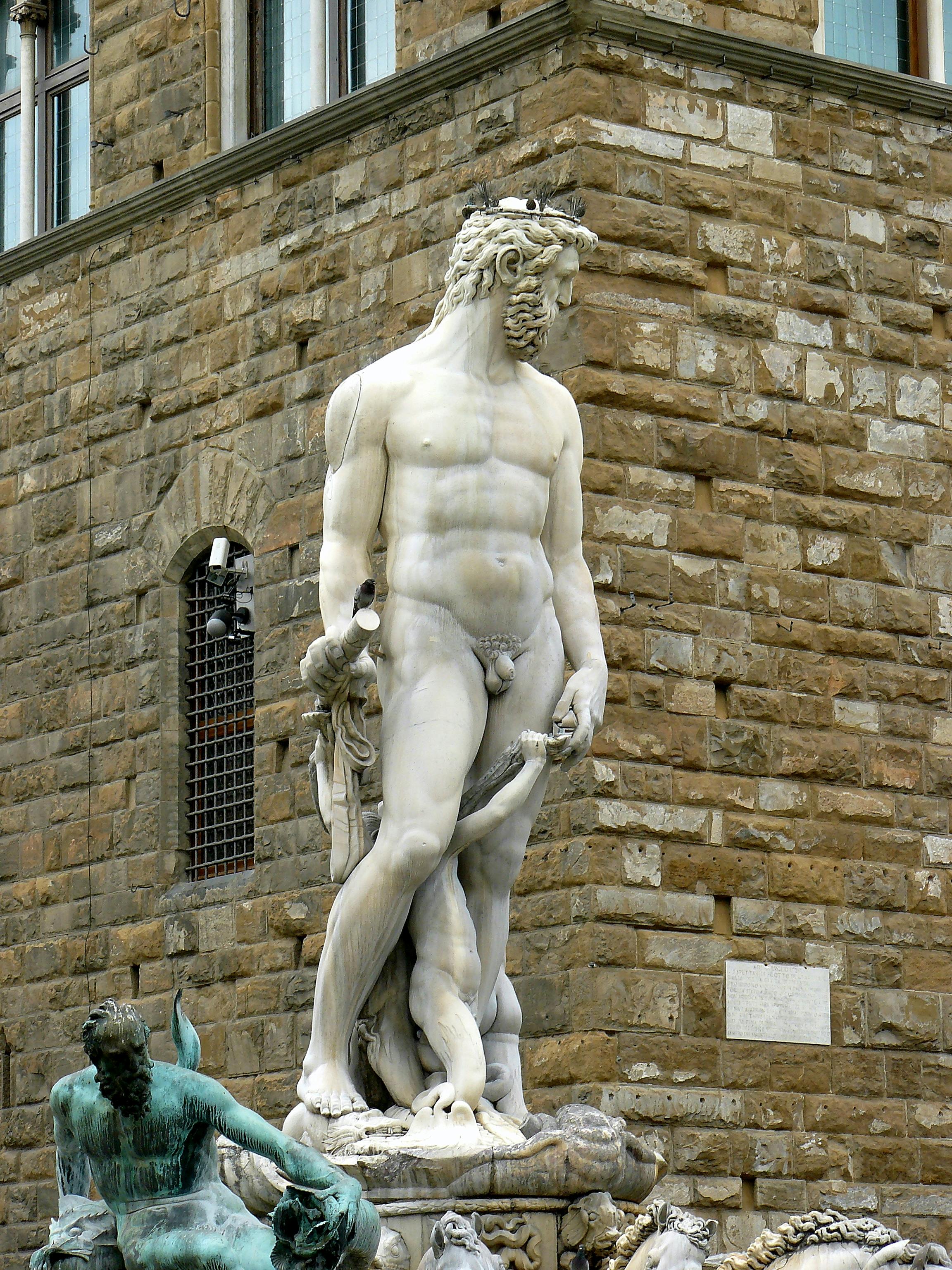 white statue of man near brown brick wall