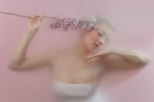 Blurred Woman in White Top with Flowers in Hand