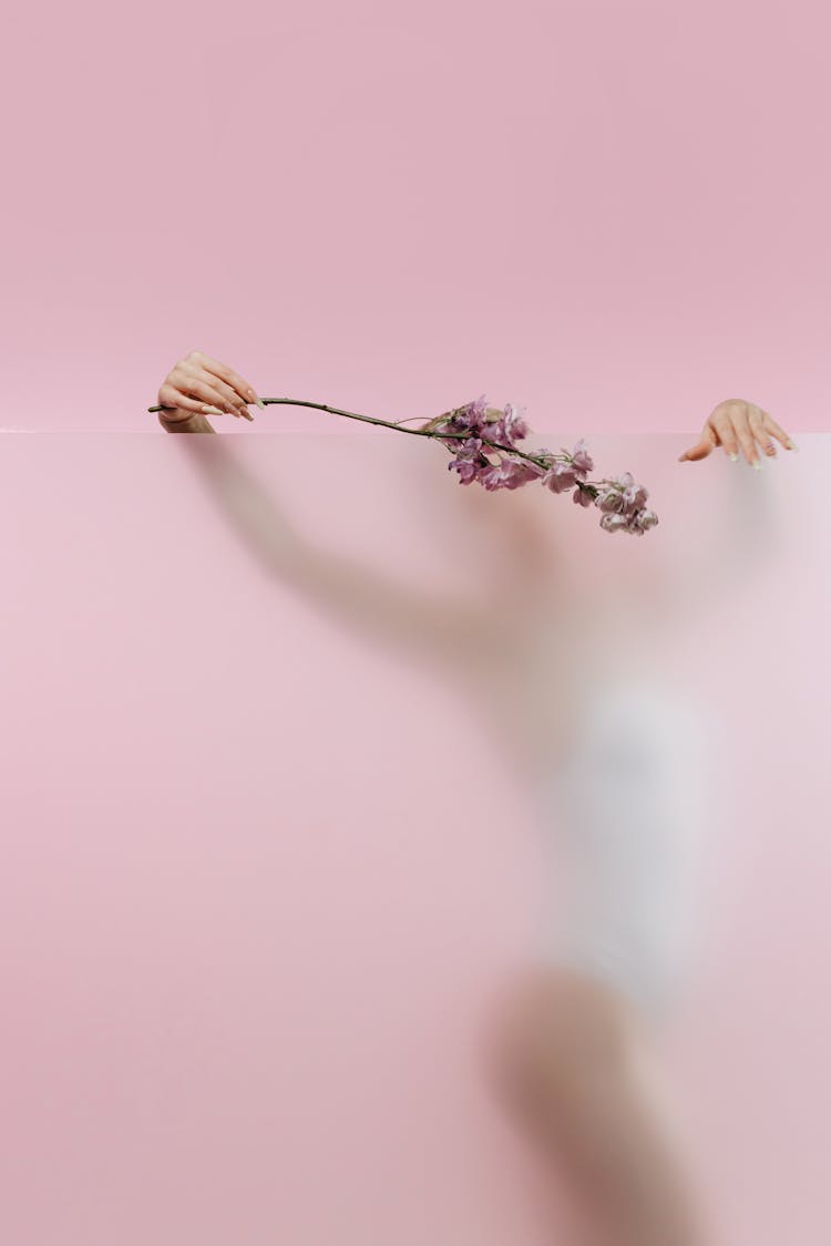 Woman Holding Flowers Over Glass