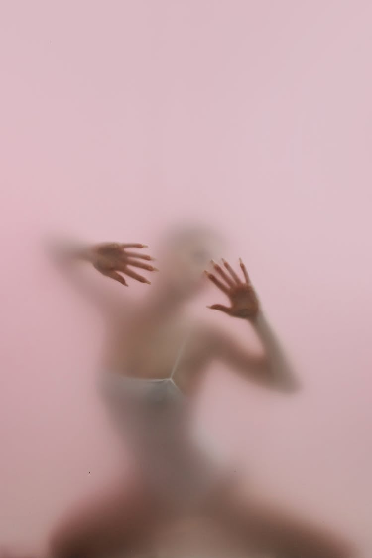 Silhouette Of A Woman Standing Behind Glass Panel