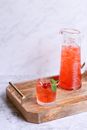 Refreshing drink with cherries in glass and carafe