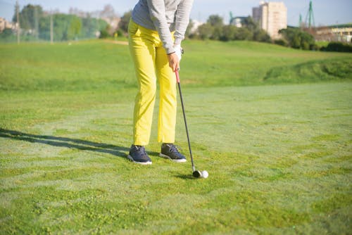 Free A Person in Yellow Pants Standing while Holding a Golf Club Stock Photo