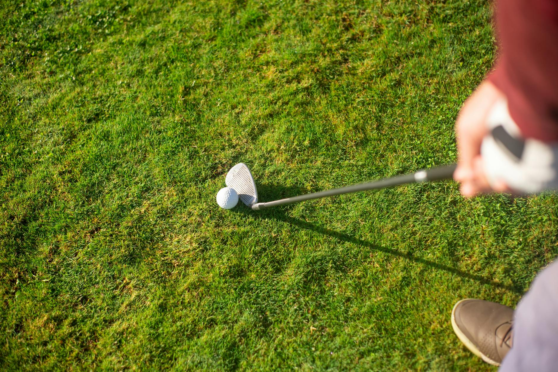 https://www.pexels.com/photo/a-person-holding-a-golf-club-near-the-ball-on-green-grass-6542400/