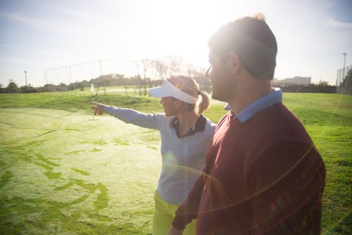 A Man and Woman Having Conversation while Standing on the Field