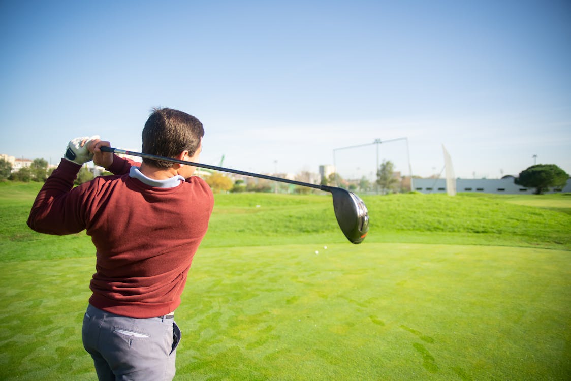 Free A Man in Red Sweater Holding a Golf Club Stock Photo