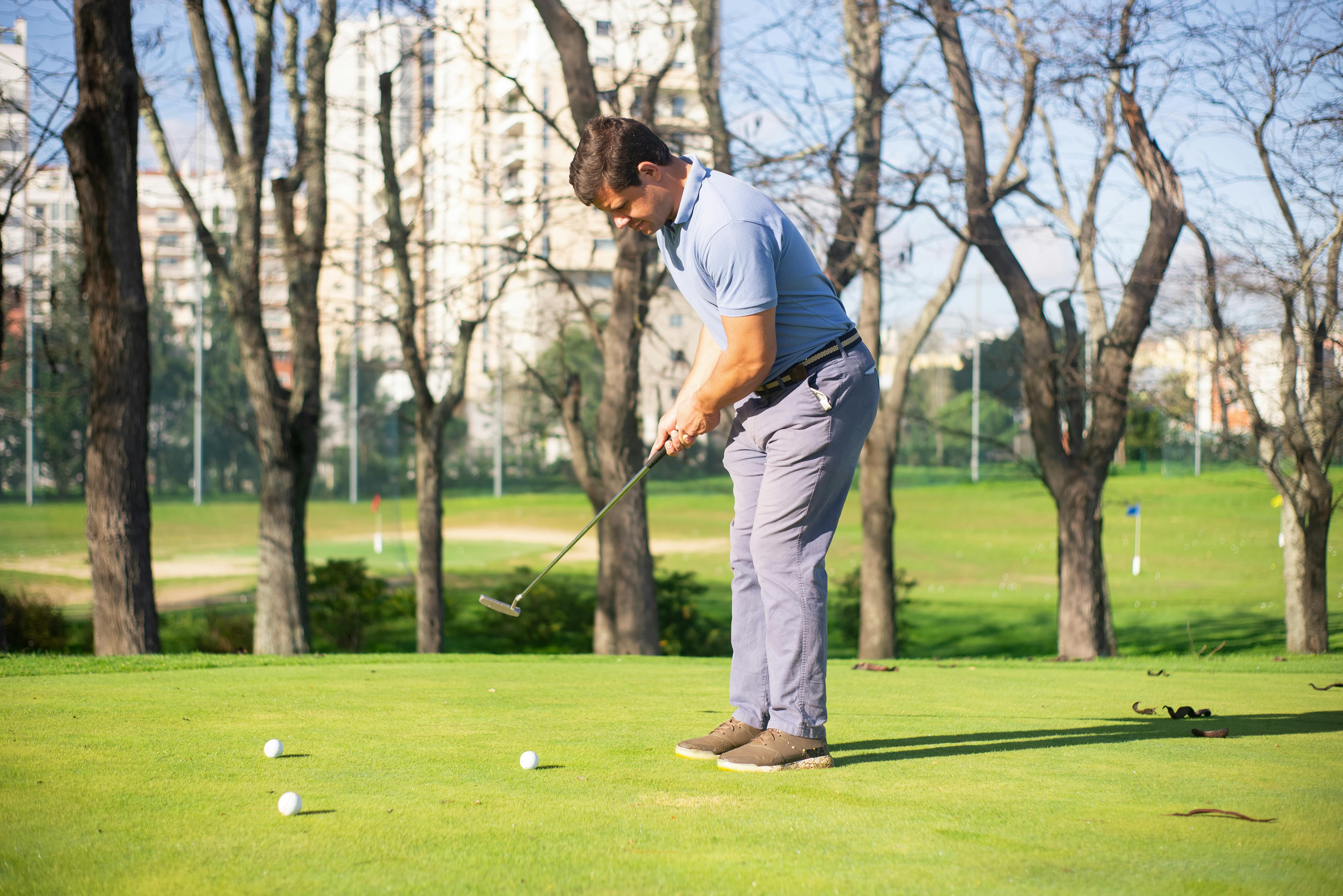 a man standing on green grass while playing golf