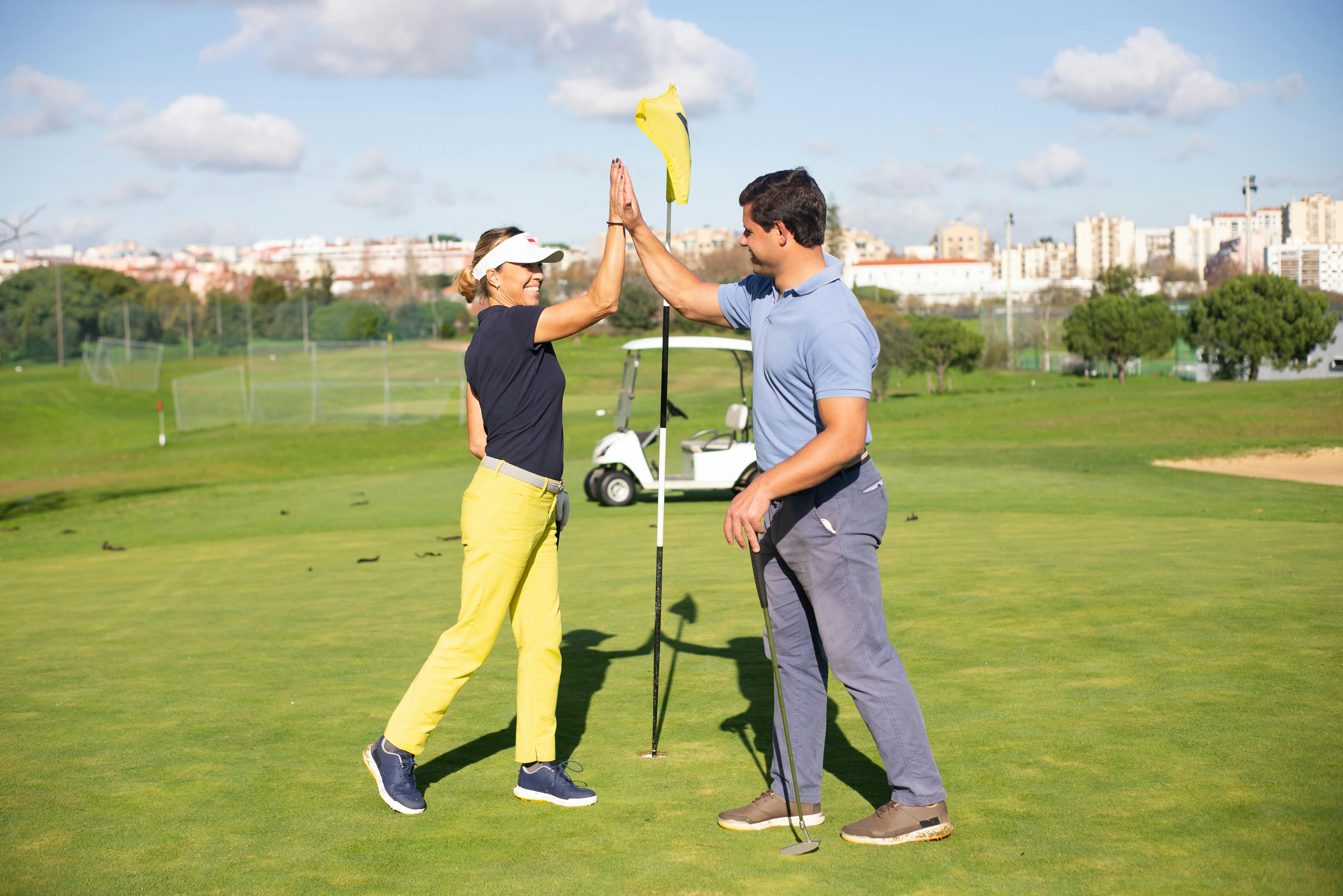 a man and woman doing high five while standing on the field