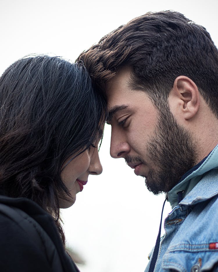 A Couple Touching Each Other With Their Foreheads